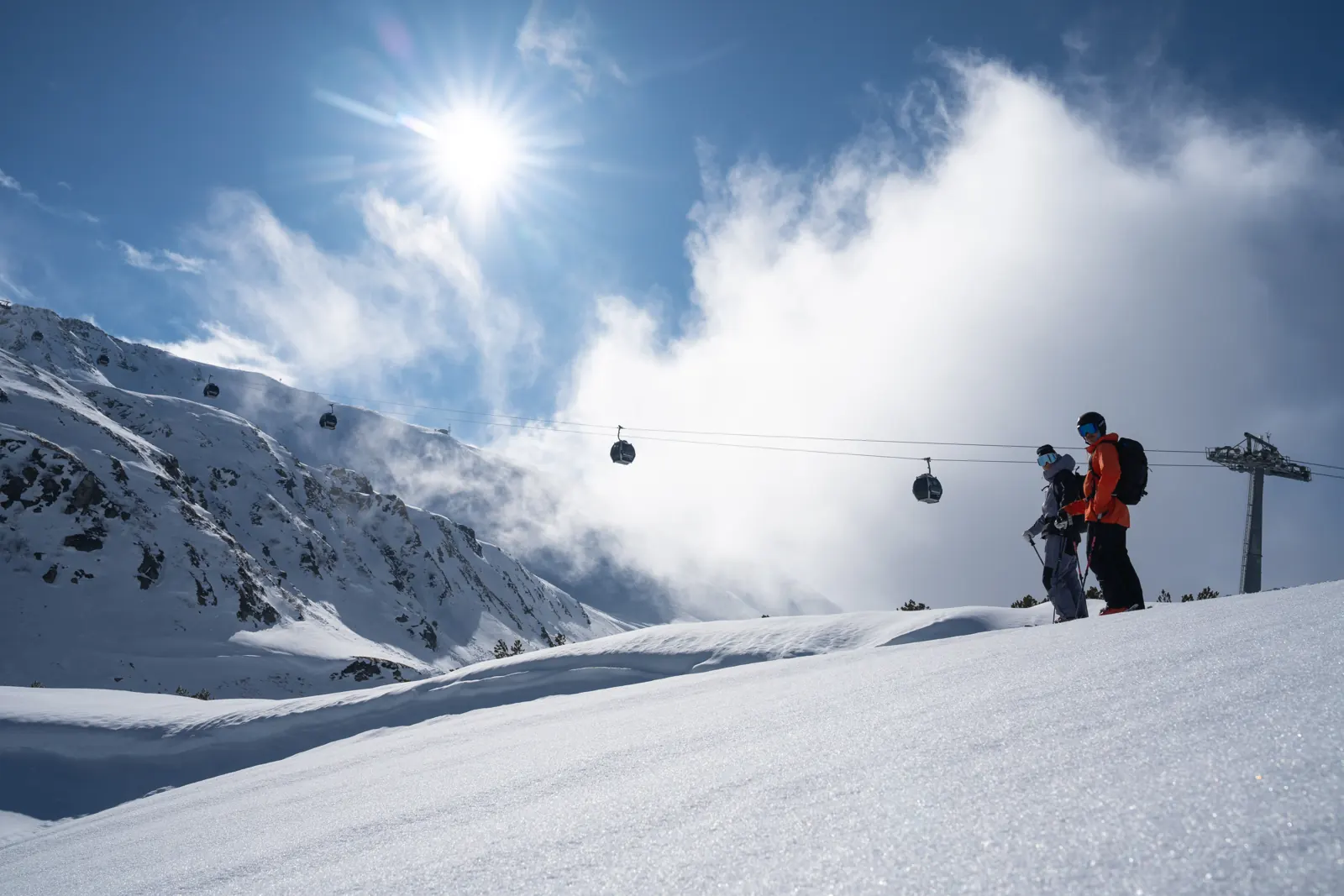 Skifahrer in der Sonne mit Gondelbahn im Hintergrund